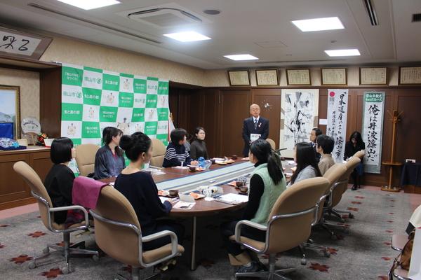 市長室に集まった篠山市に集う若手女性芸術家10名の前で立って話をしている市長の写真
