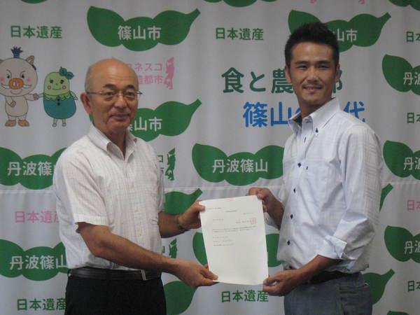 市長から和田明男さんに「青年等就農計画認定書」を交付している写真