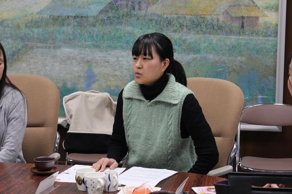 自身が手掛けた3つの違う柄のコーヒーカップの前で説明している矢倉 藍子さんの写真