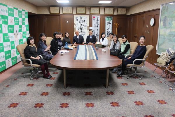 市長室に集まった篠山市に集う若手女性芸術家10名と市長が椅子に座って記念撮影した写真