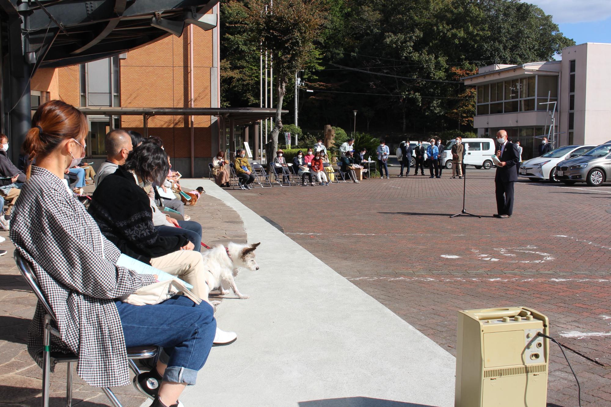 長寿犬と飼い主の前で市長が話している。