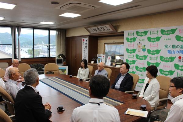 青山家第26代当主青山 忠博さんと青山 忠晴さんのご家族が市長室で市長とお話ししている写真 拡大画像