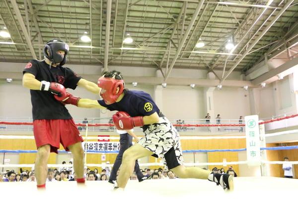 波多野慎也さんが相手に左ボディーパンチしている写真