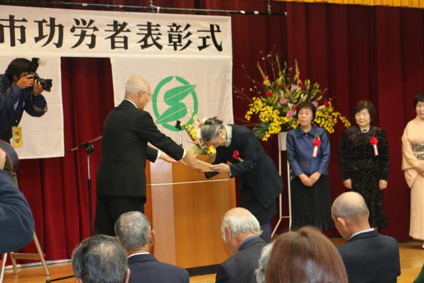 市長が丹波焼の上等の楯を受賞者の女性に贈る写真