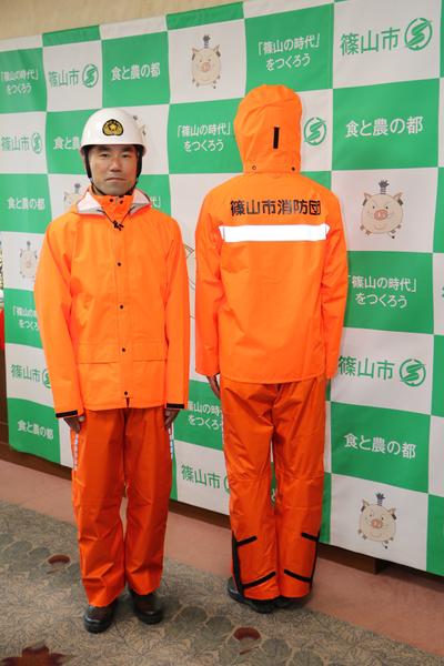 2名の消防団員でオレンジ雨がっぱを着た正面と後ろ姿の写真