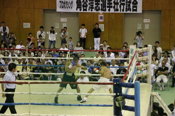 リング上で試合が行われており、観客席の方々が真剣に観戦している写真