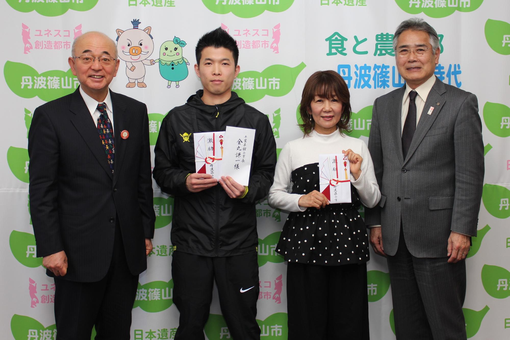 左から市長、奥山さん、三宅さん、教育長が横一列に並んでいる写真