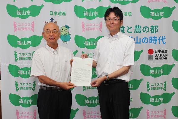 市長と井上さんが一緒に書類を持っている写真