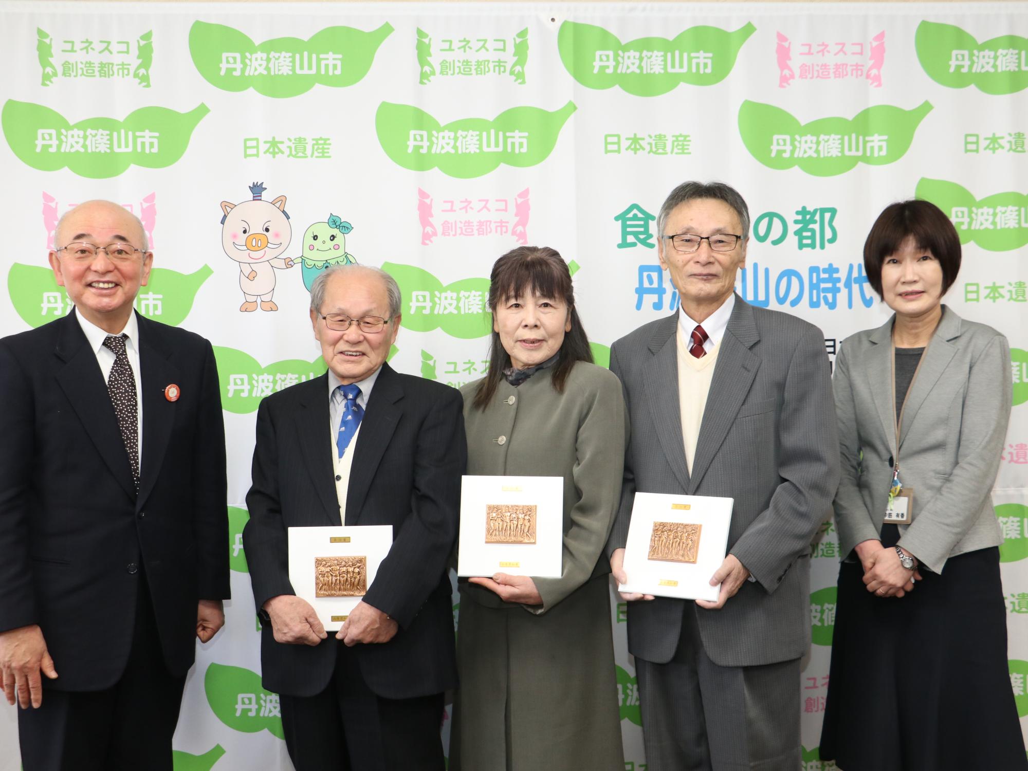 受賞者3人が表彰盾を持って、市長、市職員と記念撮影