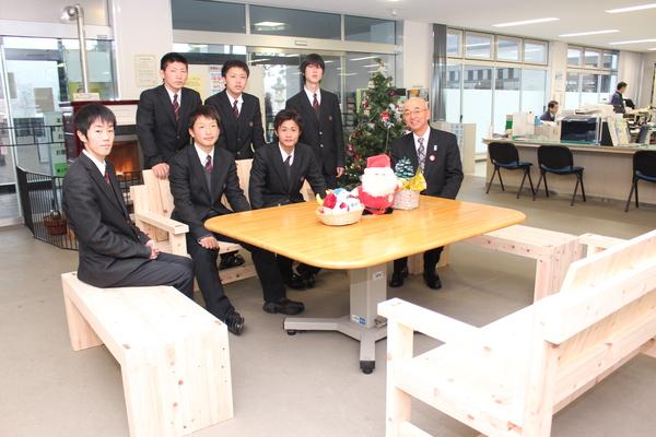 寄付された木製のベンチ4脚を囲みんだベンチに生徒3名と市長が座り3名は後ろに立った記念写真