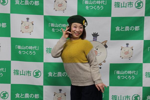 森田 まりこさんが小指と人差し指、薬指を立てて、顔の前に置き、笑顔でポースを取って写っている写真