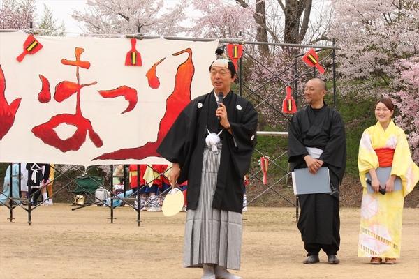 よさこい祭り会場で紋付き袴を着てちょんまげのカツラを被って挨拶をしている市長の写真