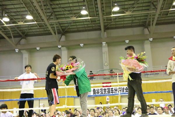 リング上で花束を手渡されている角谷 淳志選手の写真