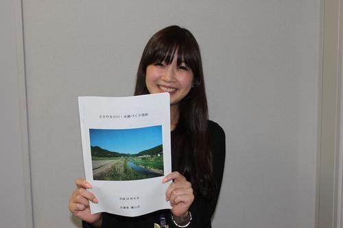 ささやまの川・水路づくり指針の資料を持って笑顔で写っている女性の写真