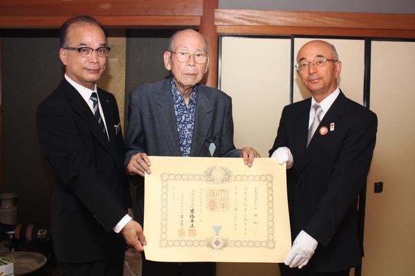 谷舖 敏一さんを真ん中に市長と関係者で賞状を持ち記念写真