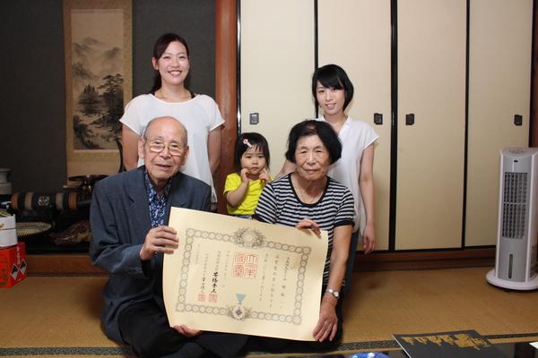 谷舖 敏一さんと奥様で賞状を持ち、お孫さん、ひ孫さんで記念写真