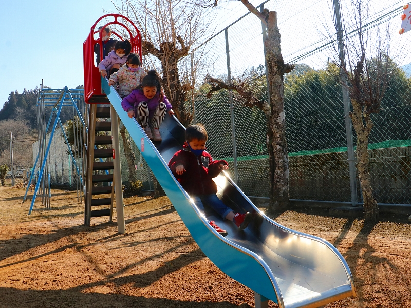 こどもたちが続けてすべりだいを滑っている