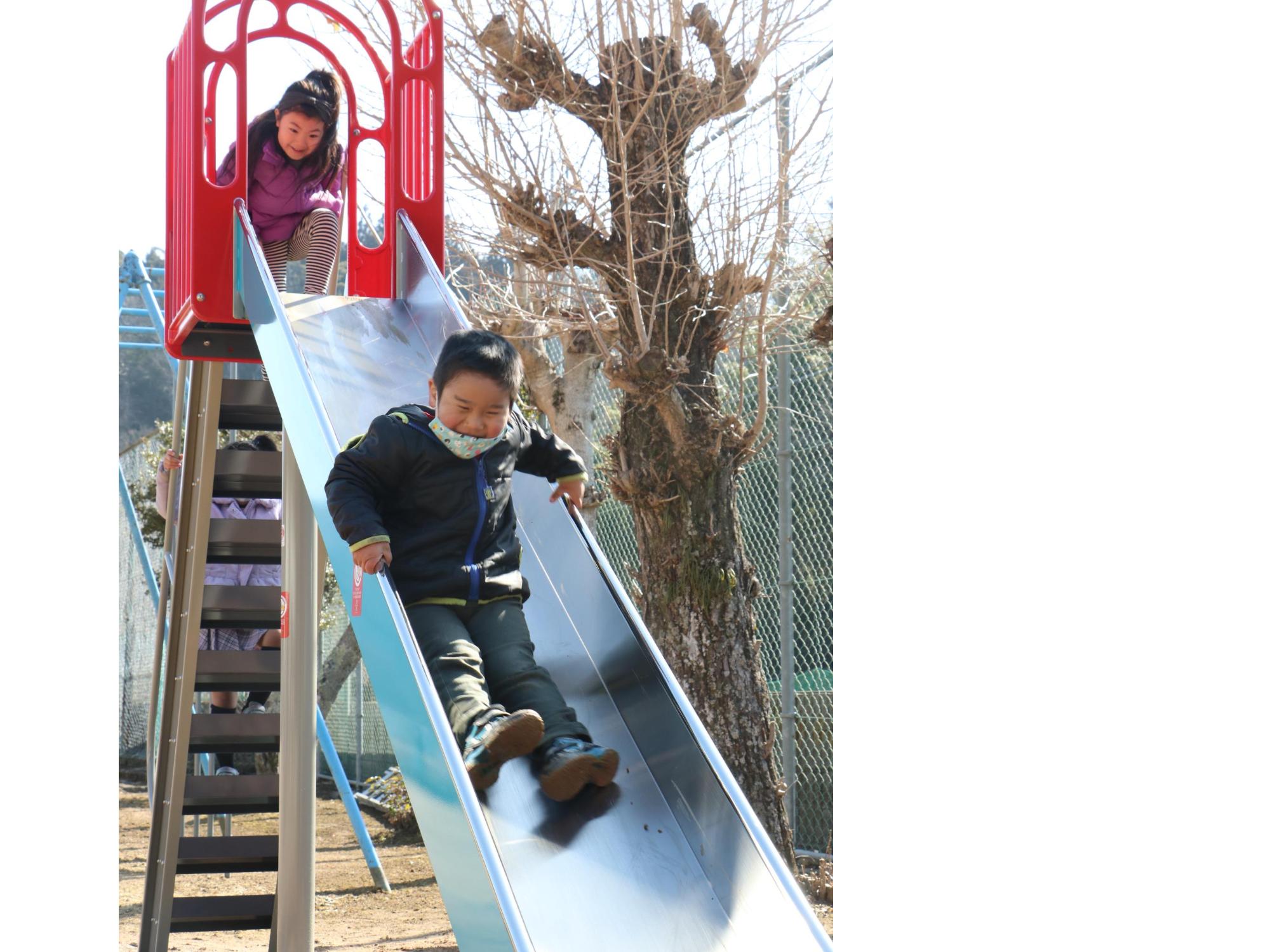 男の子がすべり台をすべっている