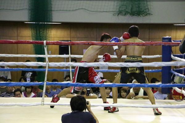 角谷 淳志選手が相手選手の左顔に右手パンチをしている写真