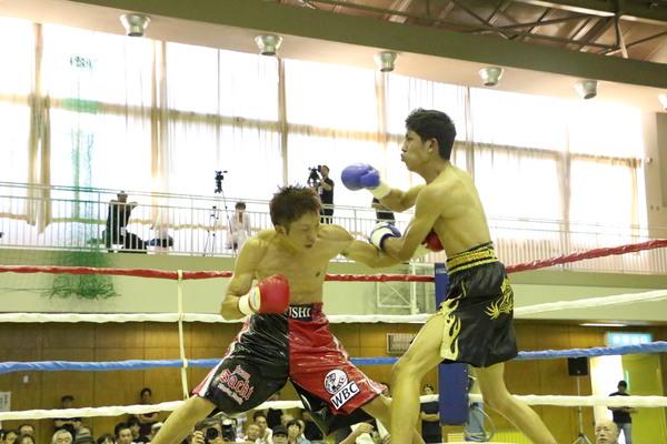 角谷 淳志選手が相手選手の右胸に左パンチをしてる写真