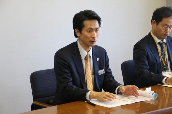 松岡所長が机に資料を広げて真剣な表情で発表している様子の写真