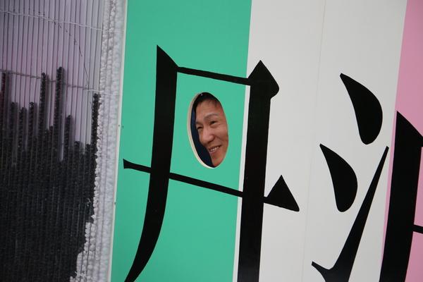 丹と書かれた文字の切り抜き部分から顔を出している男性の写真