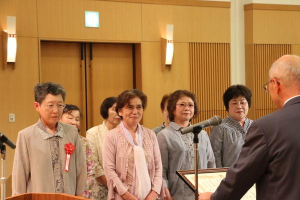 前列に4人、後列に3人の女性が並び賞状を読み上げる市長を見ている写真