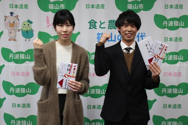 篠山市民ランナーの足立 幸子さんと雪岡 誠太さんが左手に目録を持ち右手でガッツポーズをしている写真