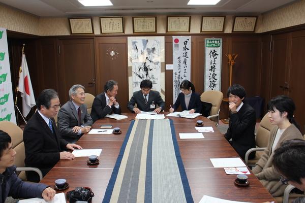 篠山市民ランナーの雪岡 誠太さんと足立 幸子さんを交えて会議室で打ち合わせが行われている様子を書記している職員の写真