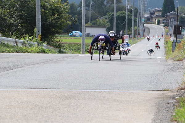 車いすマラソンで選手たちが坂道を上っている