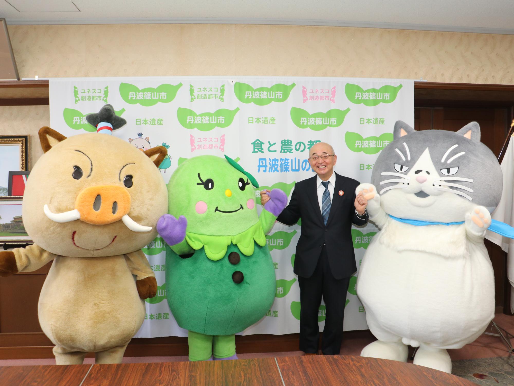 市長とデブ猫マル、まめりんが手をつないでそのとなりにまるいのがいる