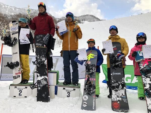 雪の中、表彰された5人が賞状を持ち、表彰台に上がっている写真