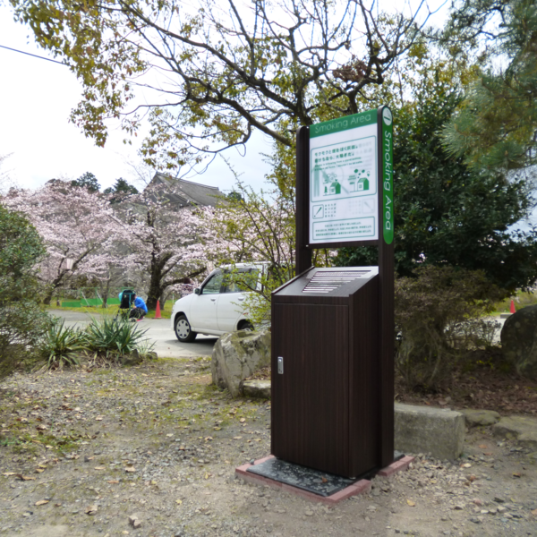 駐車場の脇に木目調の灰皿が置かれている写真