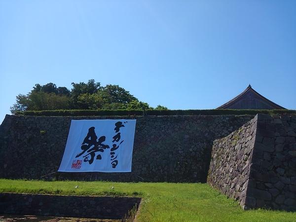 大きなデカンショ祭の旗が、石壁に飾られている写真