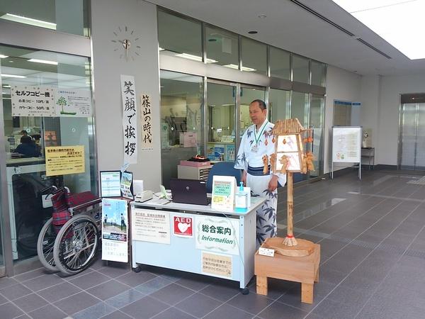 市役所入口の総合案内に浴衣姿の男性職員1名が立っている写真