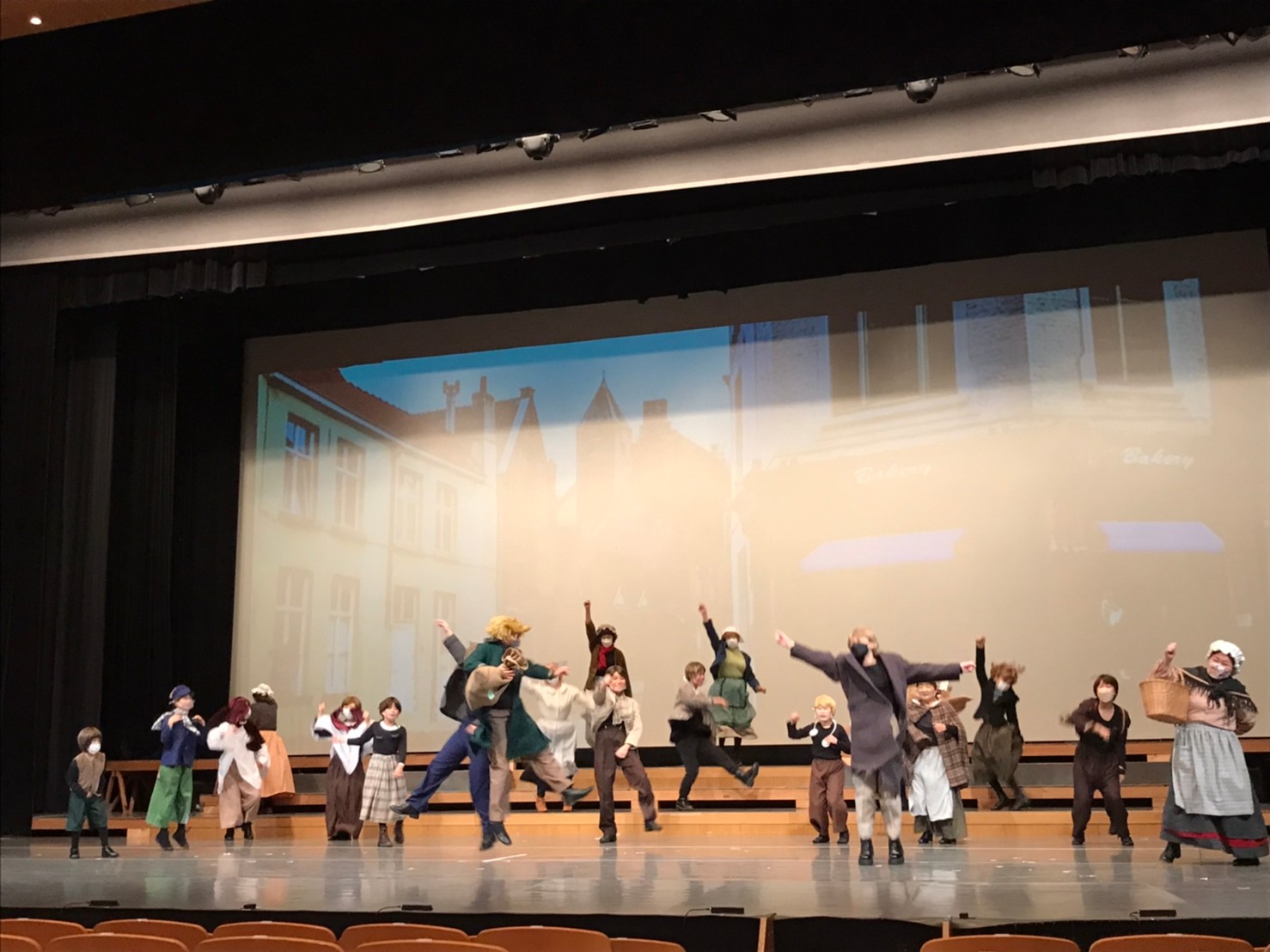 舞台の上で、衣装を着てミュージカルの練習をしている出演者