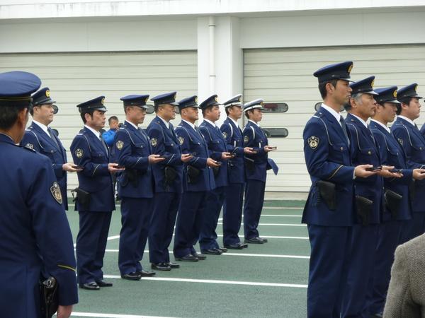 警察官が片手にピストルを持って整列している写真