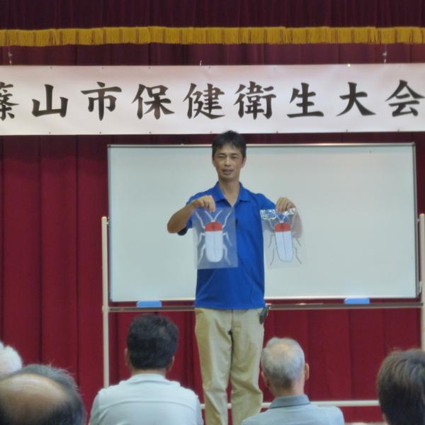 篠山東雲高等学校教諭の田井 彰人先生が紙芝居を用いてお話している写真