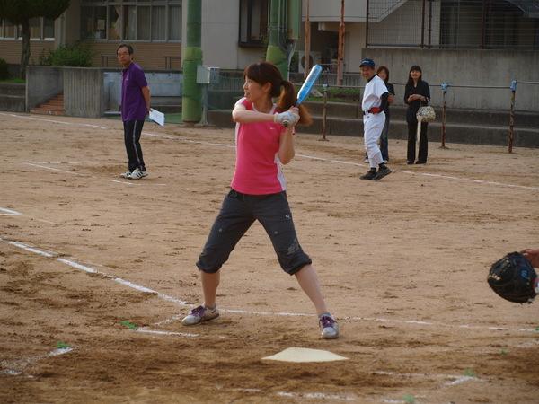 ピンク色のティーシャツを着た越川さんが、ボールを打とうとバットを両手で握り、構えている様子の写真