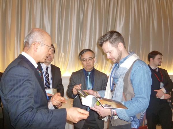 篠山市のパンフレットを見るロバート・ランバートさんへ市長が手ぶりでお話をしている様子を聞いている山野市長の写真