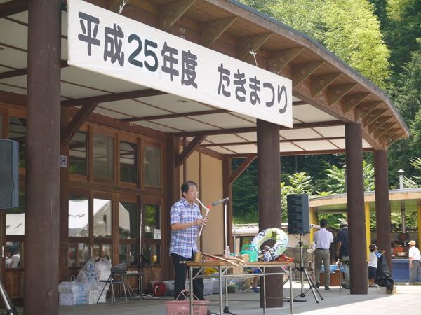 マエストロ足立さんがポンプで楽器作成し演奏している写真