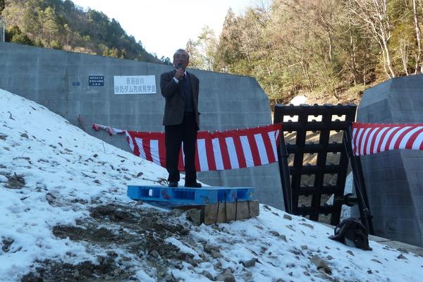 砂防ダム前で、味間新の齊藤自治会長さんが挨拶をしている写真