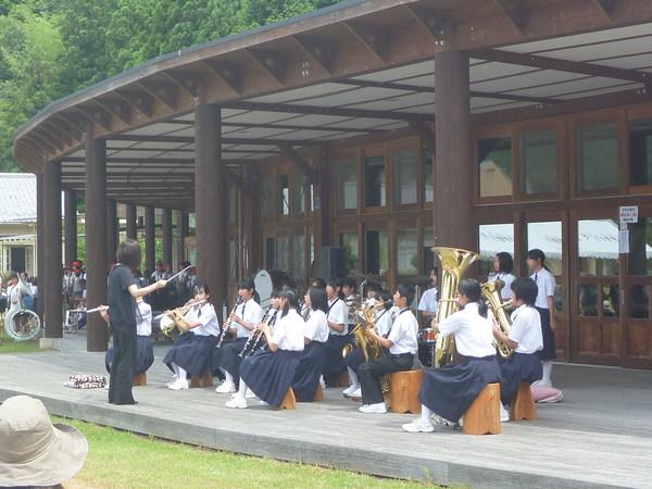 吹奏楽部の生徒が指揮者を見ながら演奏している写真