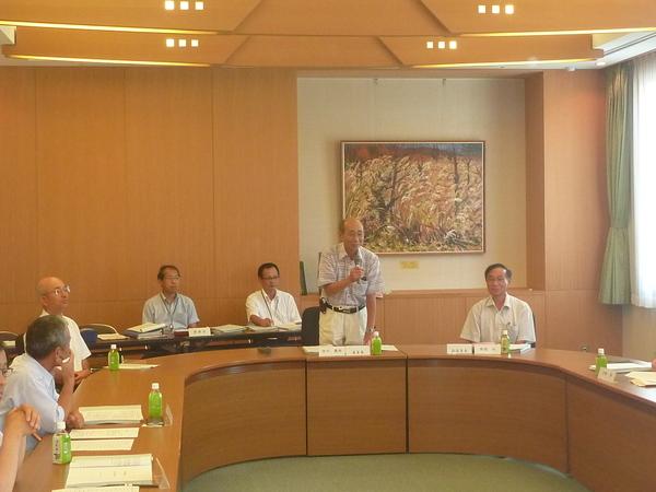 委員会で右手にマイクを持ち話しをしている中川委員長の写真