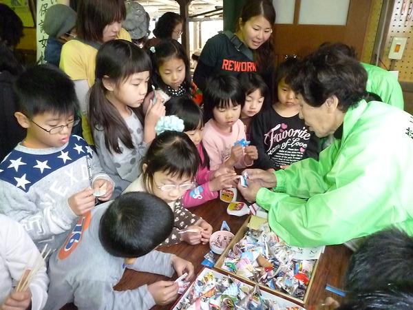 協議会の方の説明を受けて工作をしている子供たちの写真