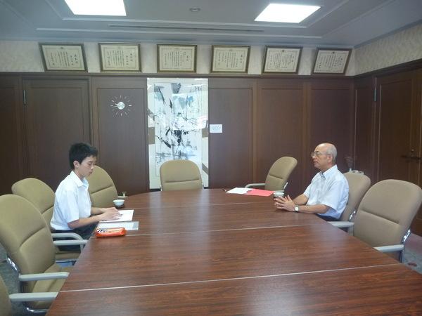 竹見 晃輔（たけみ こうすけ）君が資料を見ながら市長に質問している写真