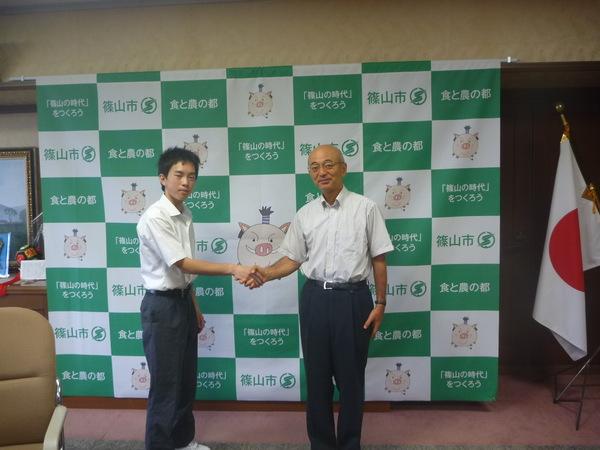 市長と竹見 晃輔（たけみ こうすけ）君が握手をして写っている写真