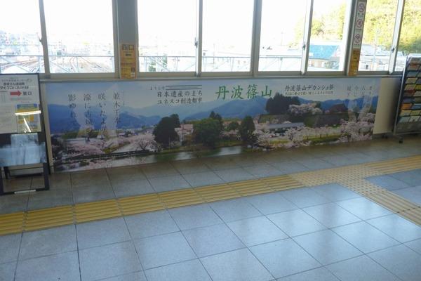 篠山口駅内に、丹波篠山の桜満開のポスターがあり、視覚障害者誘導用ブロックがある写真