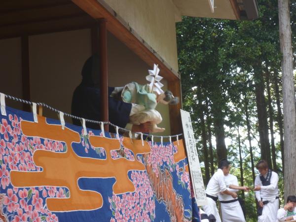 黒子さんが人形で、上半身を曲げる姿勢を作っている写真