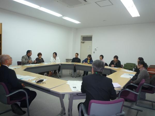 長机を四角状に並べ11名の方が椅子に座り話し合いをしている全体の様子を写した写真